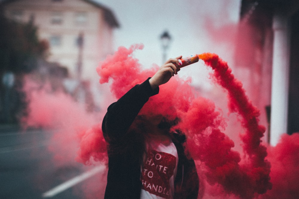 person holding canister with smoke