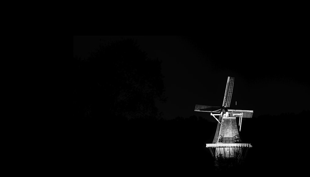 Una foto en blanco y negro de un molino de viento por la noche