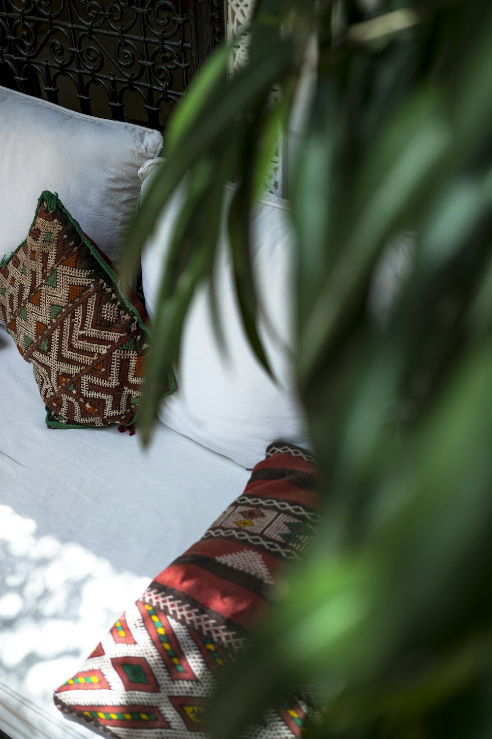 almohada roja y marrón sobre cama blanca