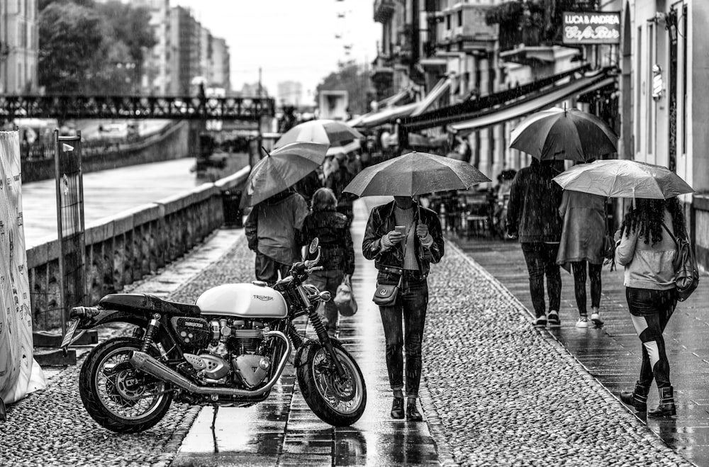 pessoa sob o guarda-chuva ao lado do motociclista