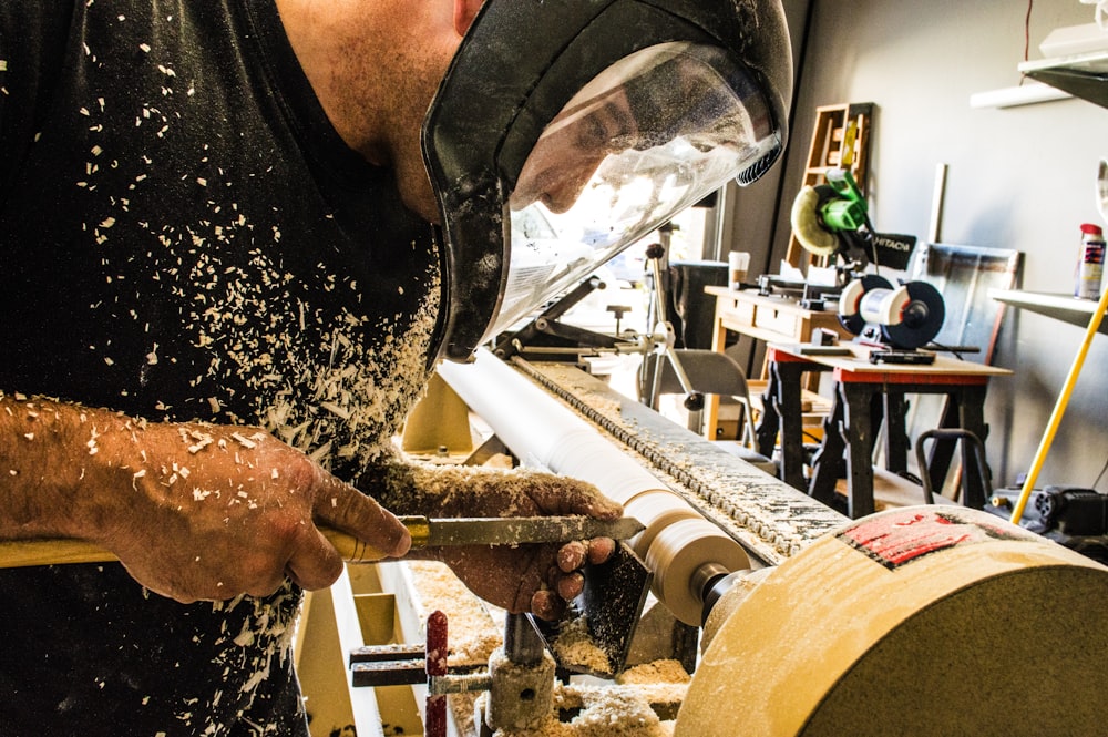 Mann mit Schweißhelm vor Industriemaschine