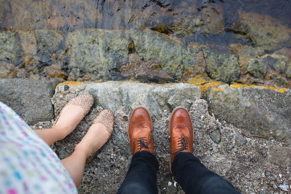 foto di donna e uomo in piedi vicino allo specchio d'acqua