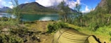 A serene campsite with a tent set up by a lake.