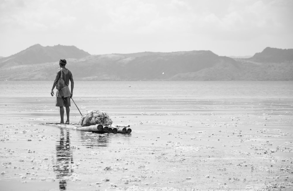 Photo en niveaux de gris d’un homme chevauchant un bateau