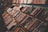 Books are neatly arranged on several wooden shelves in a bookstore or library setting. The shelves are filled with a wide variety of books, showcasing both hardcovers and paperbacks, with colorful spines displaying different titles and authors.