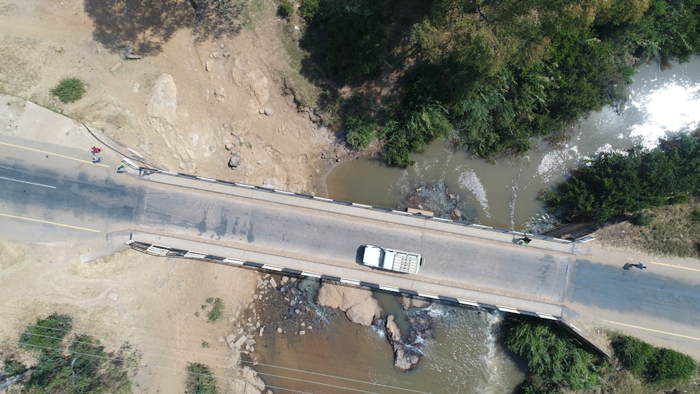 bird's eye view photo of white vehicle on bridge during daytime