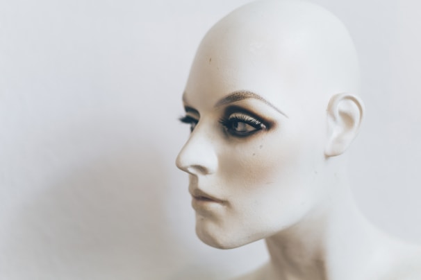 Close-up of a student practicing dermocosmetic techniques on a mannequin head