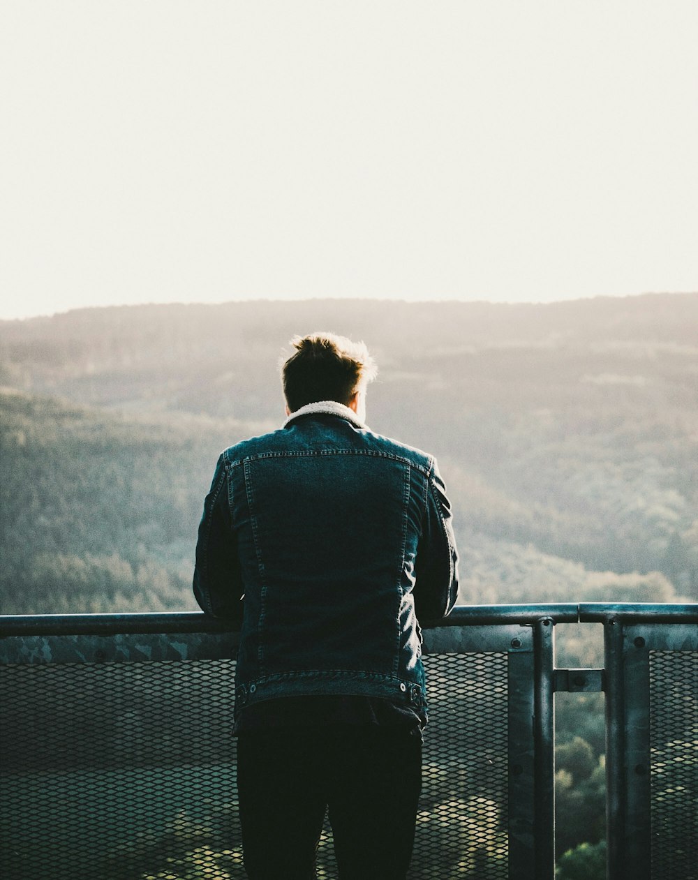 man in green jacket looking at horizon during daytime