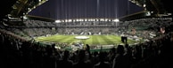 Panoramic view of the stadium lit up at night, filled with cheering supporters.