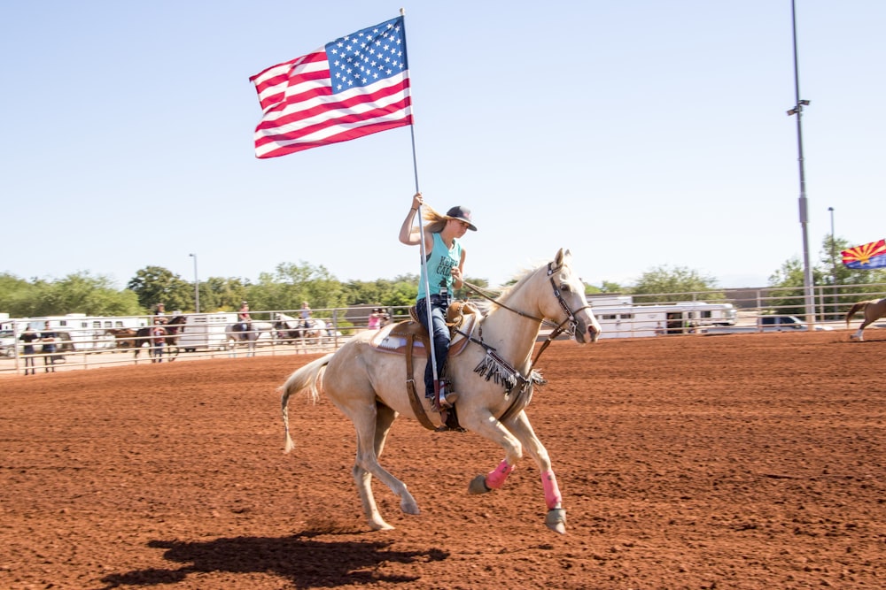 woman riding horse holding flag