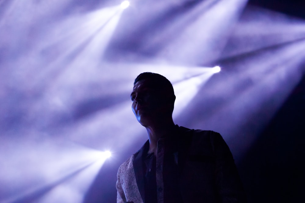 man's silhouette on stage reflected by stage lights