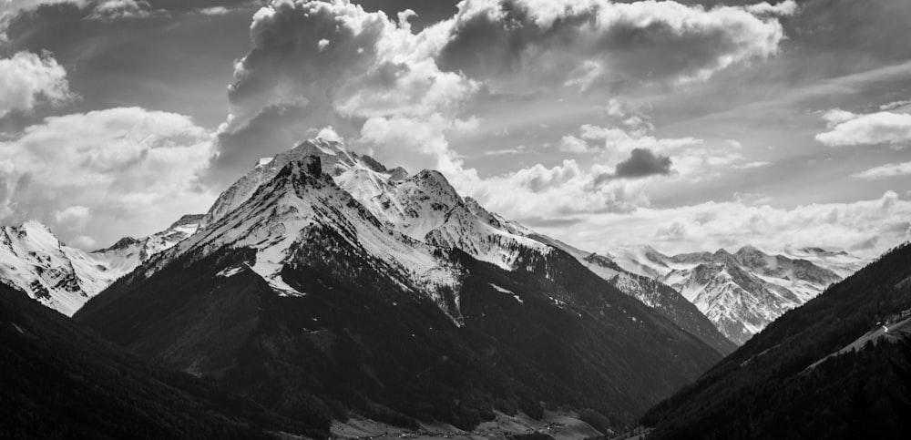 grayscale photo of mountain under clouds