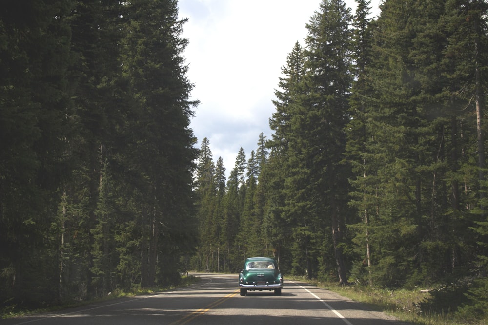 photo of blue car on road