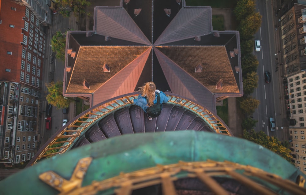 high angle photography of woman standing in the stair while looking at the ground