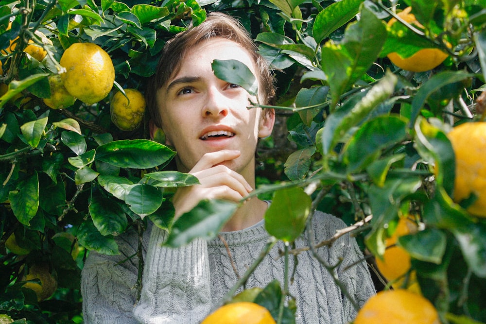 man holding his jaw surrounded by yellow fruit