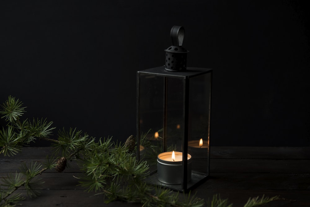 lighted candle inside black lantern holder
