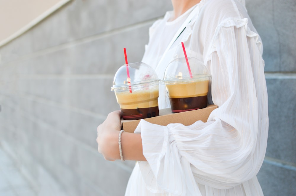 woman carrying disposable cups