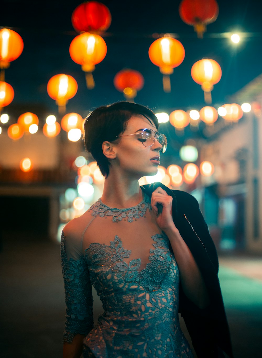 boke photography of woman in blue floral lace top carrying jacket