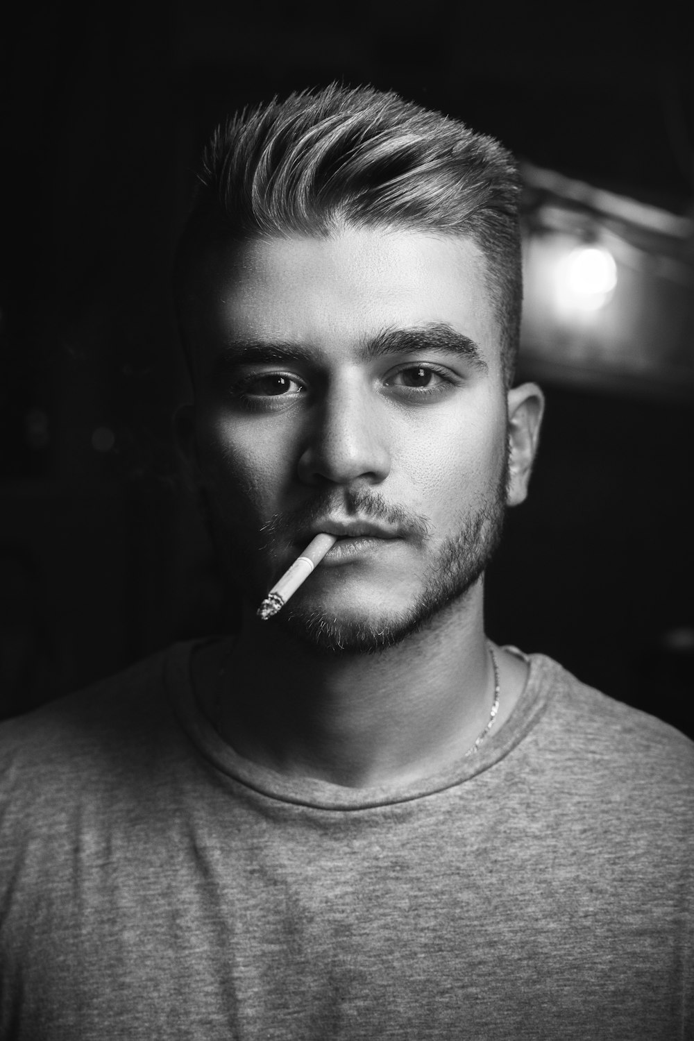 grayscale photography of man smoking while taking picture