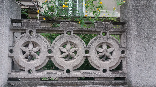 Elegant stamped concrete patio featuring intricate patterns and warm earthy tones surrounded by garden landscaping.