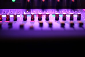 A sleek mixing console bathed in moody blue lighting, showcasing analog knobs and faders.