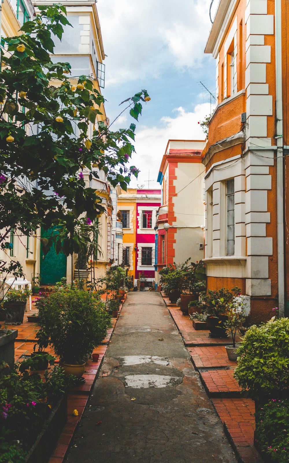 photo of narrow road beside concrete houses during daytime