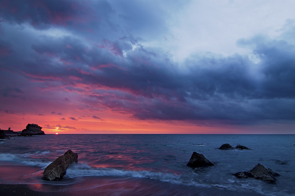 agua de mar con formaciones rocosas bajo nubes grises