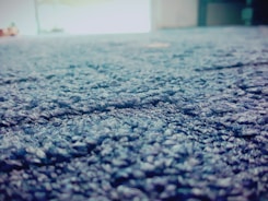 A vibrant blue rug being carefully cleaned with specialized equipment in a home.