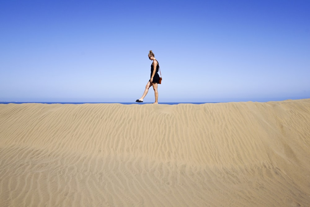 homme marchant sur sandune