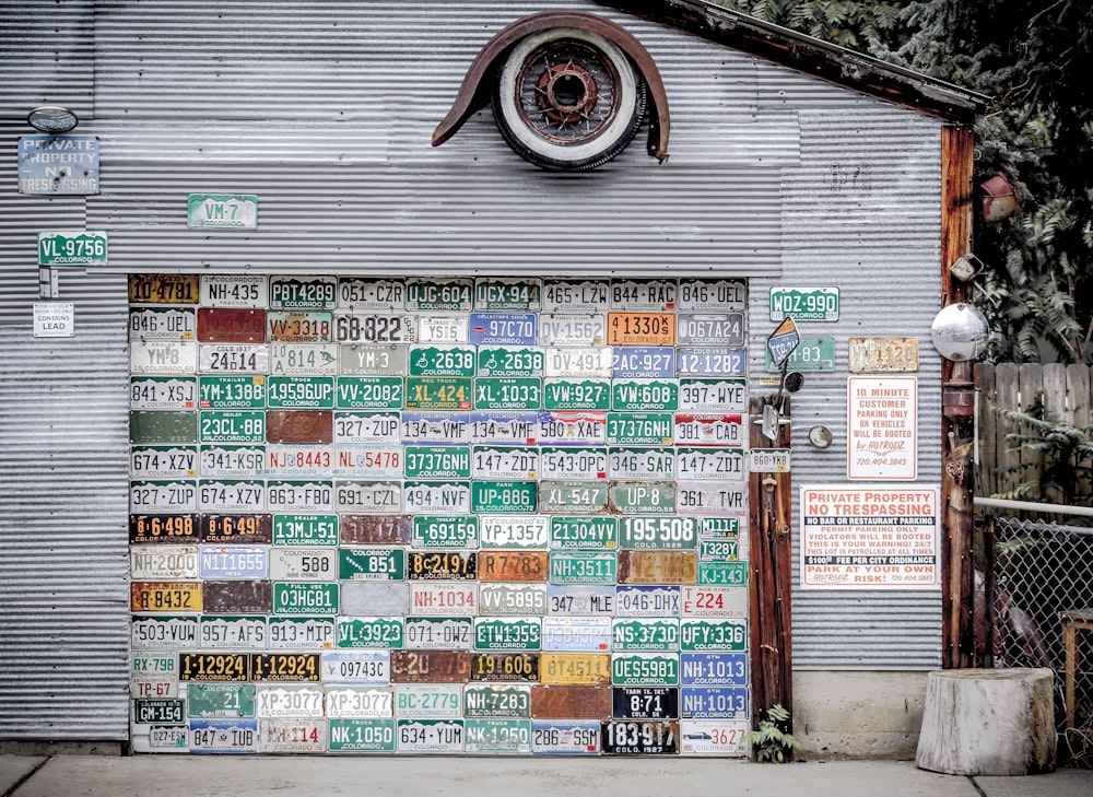 assorted license plates hanging on gray wall