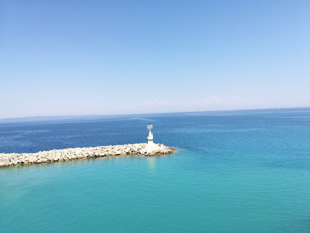 white lighthouse surrounded with body of water