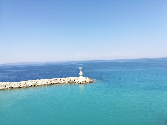 white lighthouse surrounded with body of water in Zakinthos Greece