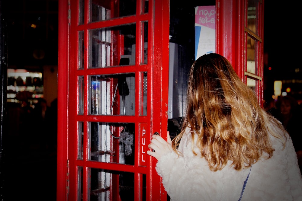 woman about to open the phone booth