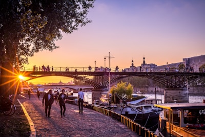 Sunset view over the scenic Naperville Riverwalk with people strolling along the water.