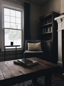gray throw pillow on black chair by the window