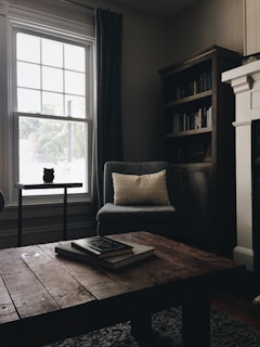 gray throw pillow on black chair by the window