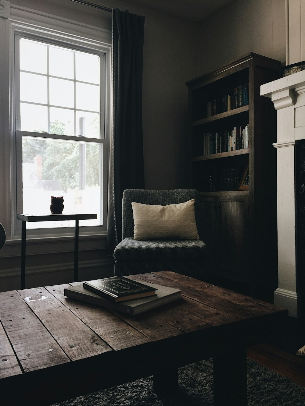 gray throw pillow on black chair by the window
