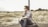 man in white and black plaid sport shirt sitting on tire