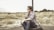 man in white and black plaid sport shirt sitting on tire