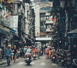 people walking on road between buildings