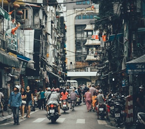 people walking on road between buildings