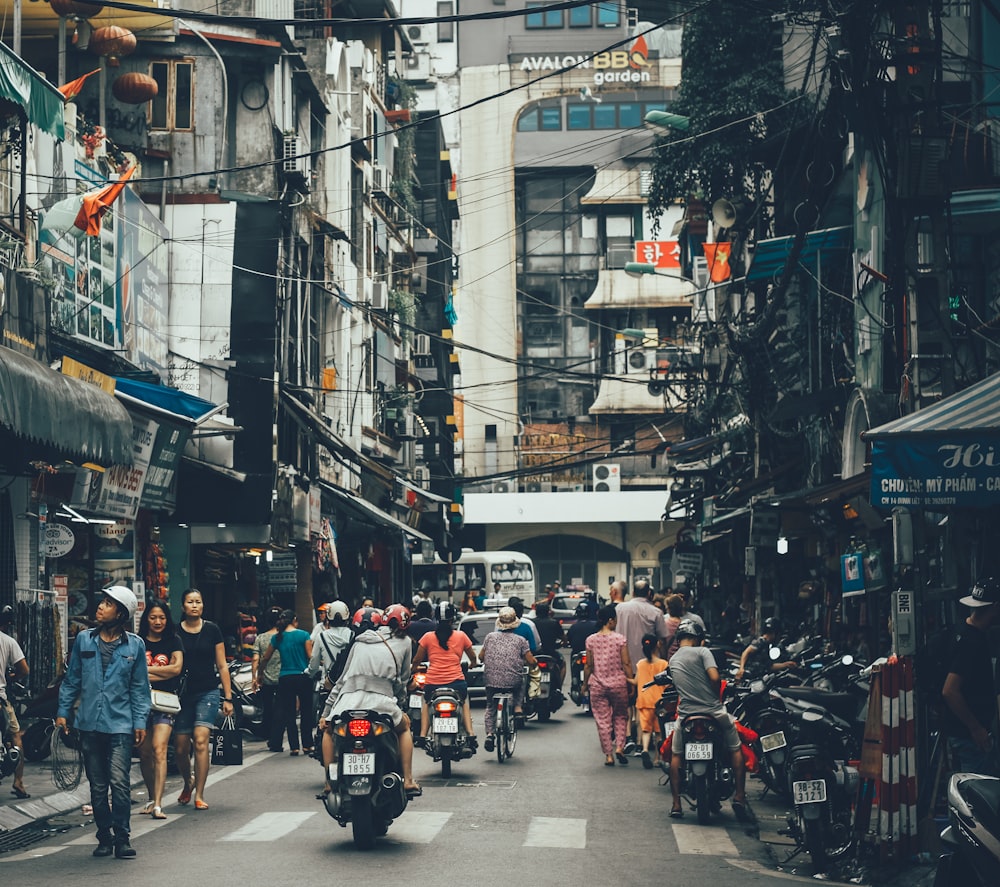 people walking on road between buildings