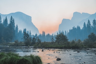 landscape photography,how to photograph i was freezing cold staying in the tent cabins in half dome (formerly curry) village in yosemite valley with my dad who was there for work, so i got up and drove around the valley at 6 am. there’s been lots of fires in the area and the valley was filled with this thick smoke. stopped at a turnout near tunnel view and shot this photo - i really love the symmetry of it and the smooth gradients the smoke produces.; body of water surrounded by trees