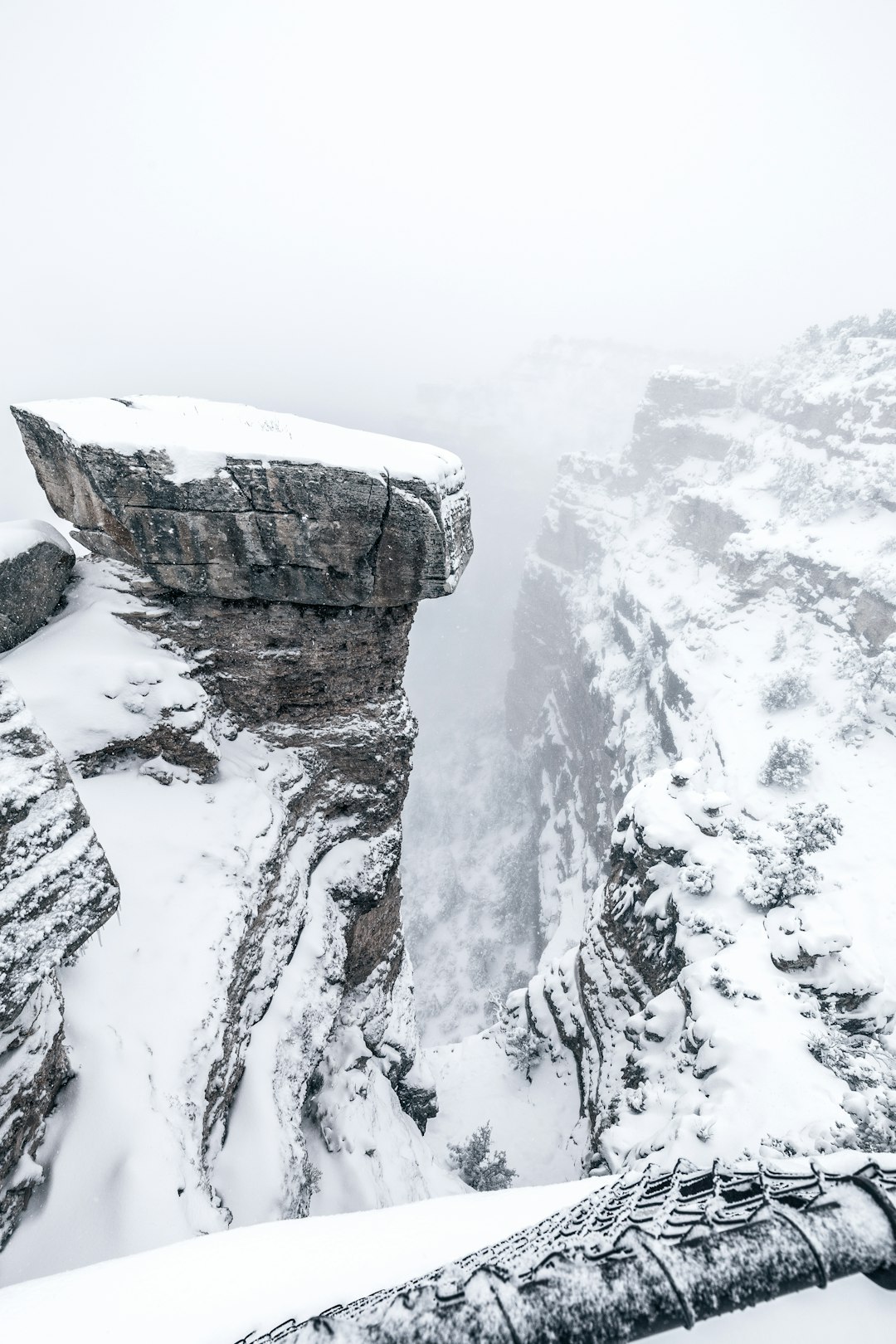 snowy cliff under foggy sky