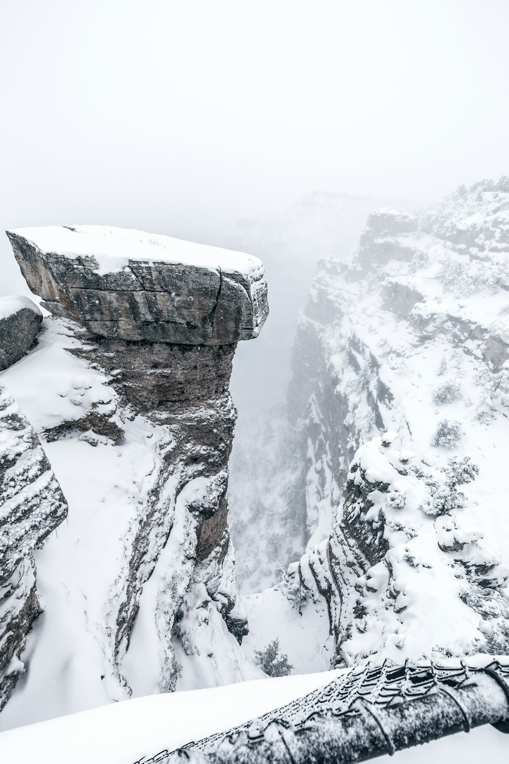 snowy cliff under foggy sky