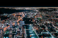 An aerial view of a bustling Australian cityscape at night with digital network lines overlayed, representing online security coverage.