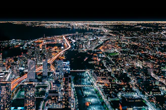 An aerial view of a bustling Australian cityscape at night with digital network lines overlayed, representing online security coverage.