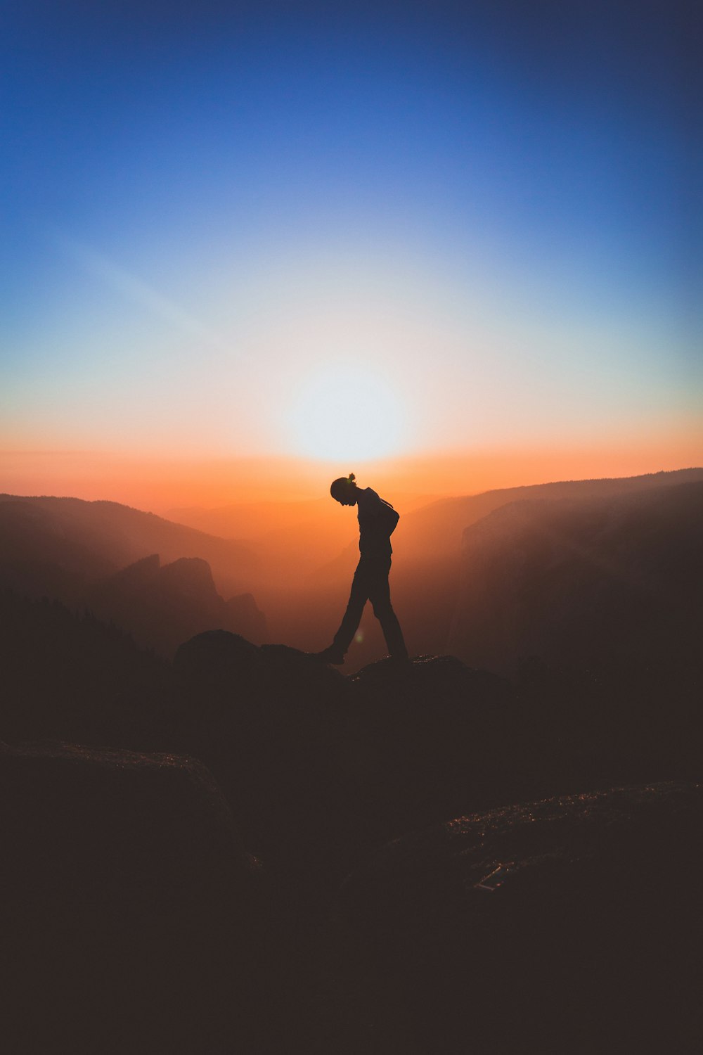Silhouette eines Mannes, der auf dem Berggipfel steht