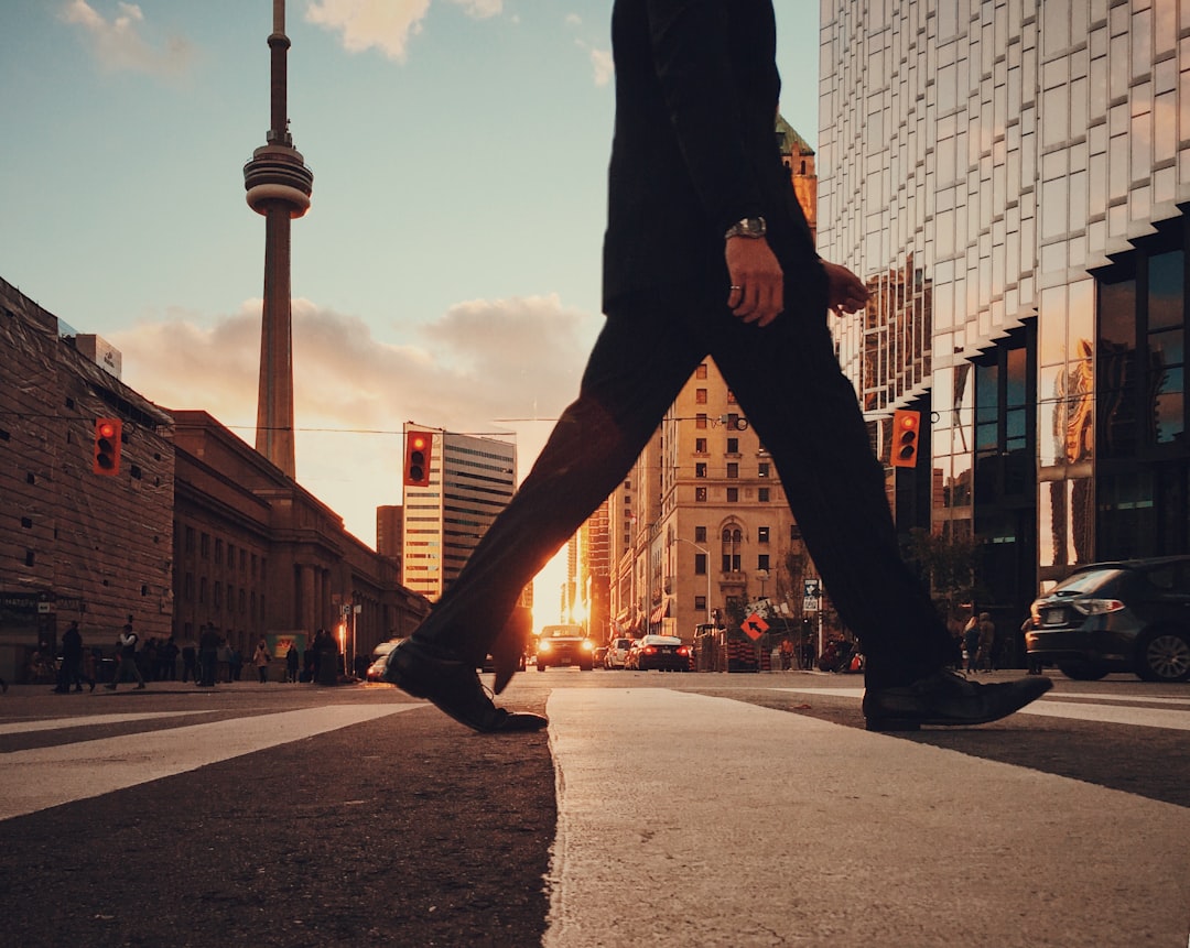 man in dress suit outfit walking in front of building, Crossing