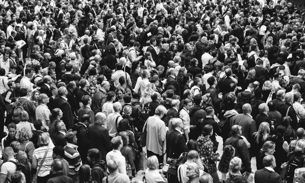 grascale photo of people standing on ground\